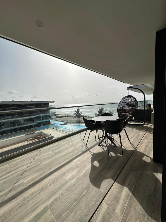 Sere KundaFar Out Apartments - Kololi Sands的海景阳台上的桌椅