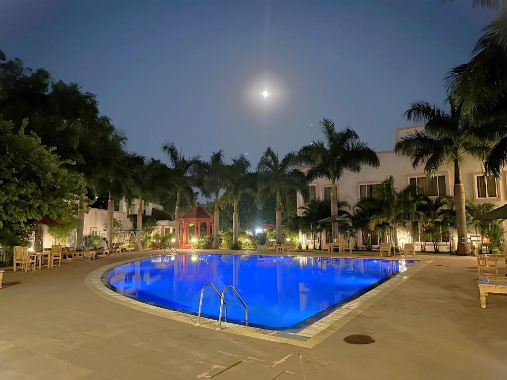 克久拉霍A S Hotels的夜间游泳池,上面有月亮