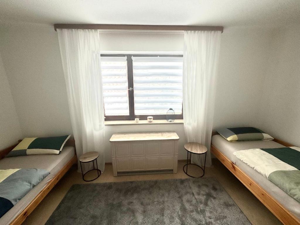 奥格斯堡Schönes, friedliches Zimmer的一间卧室设有两张单人床和一个窗户。