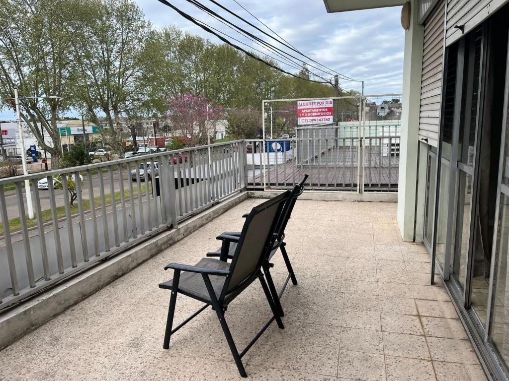 派桑杜Relax V的两把黑色椅子坐在带围栏的阳台上