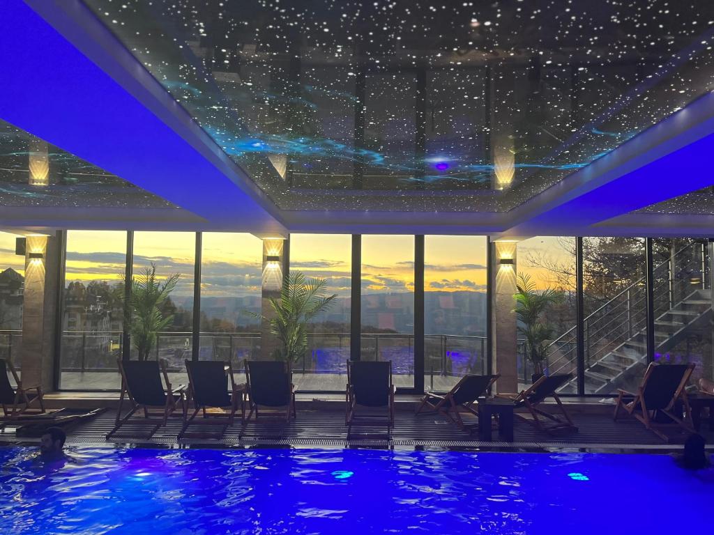 科帕奥尼克Milmari Resort - Apartman L43的酒店带椅子的游泳池,享有城市美景