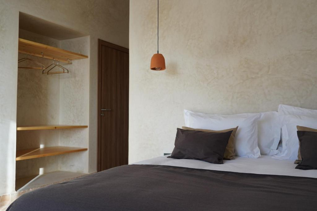 依索安L'Oued the lodge的一间卧室配有带白色床单和枕头的床。