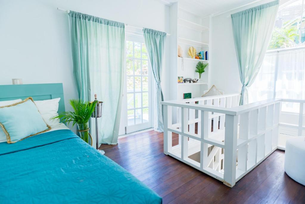 BelmontBay House Grenada的白色的卧室设有床和窗户