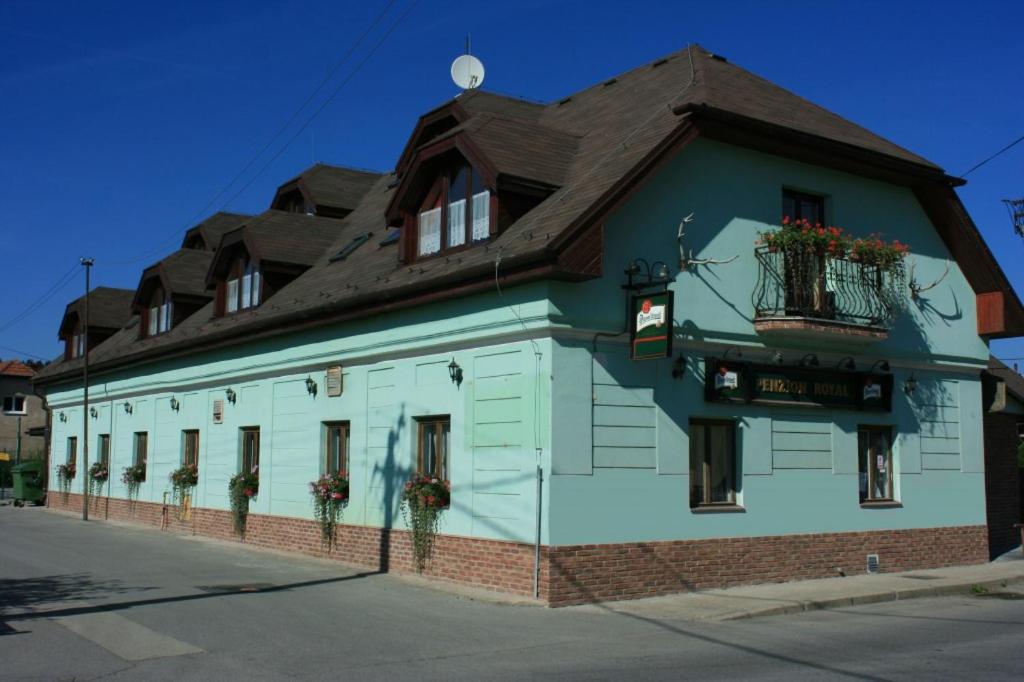 BytčaPenzión ROYAL的蓝色和白色的建筑,带有棕色的屋顶