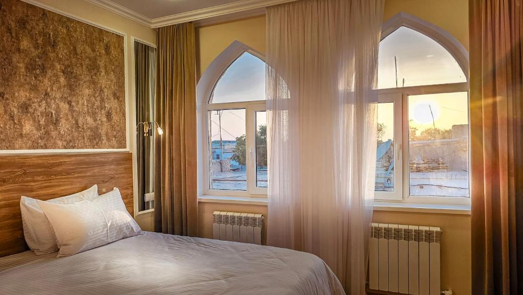 希瓦Hotel Bankir Khiva的一间卧室设有一张床和两个窗户。