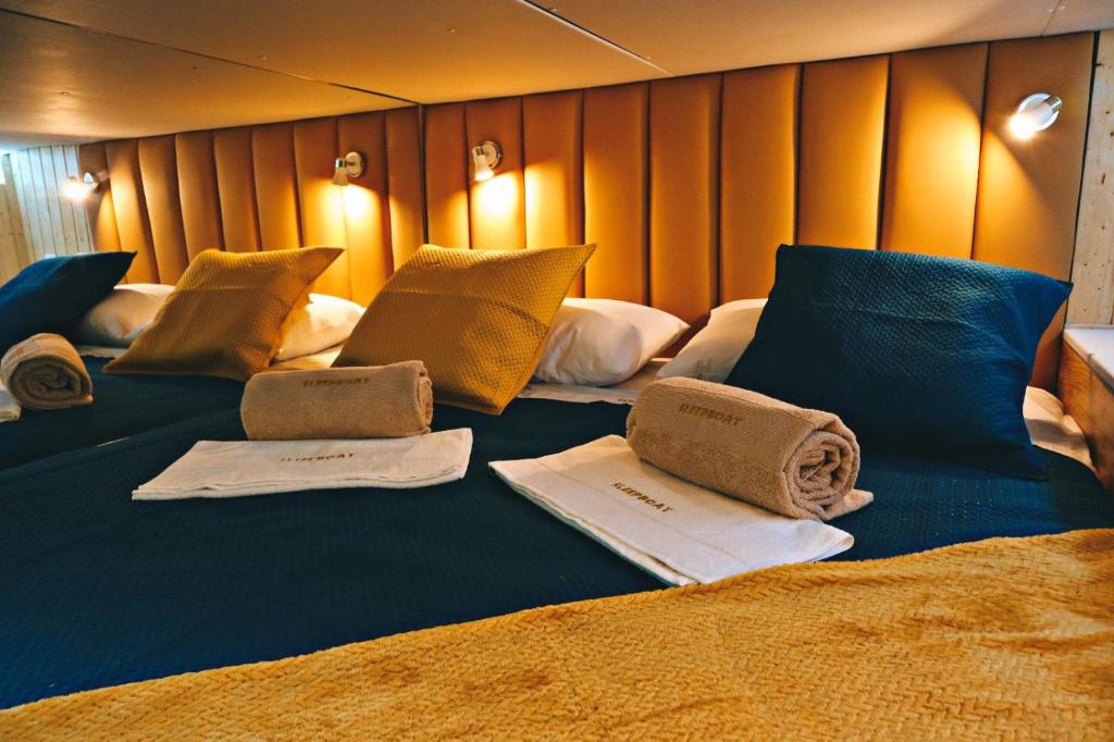 波尔图SLEEPBOAT LuxLife Yatch的一张大床,配有毛巾和枕头