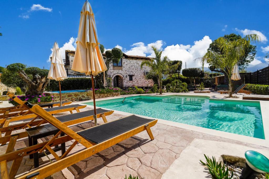 Káto YerakaríonArt House Villa的房屋前的游泳池配有椅子和遮阳伞