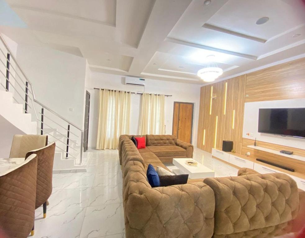 拉各斯Luxury 4 bedroom shared shortlet apartment lekki的客厅配有大沙发和平面电视