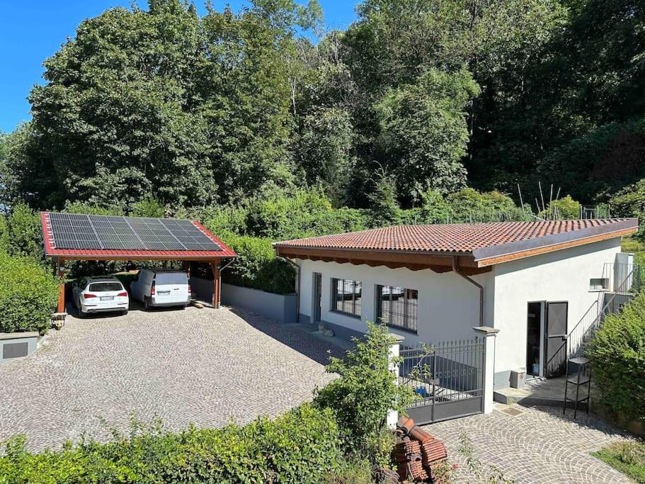 都灵La casa di Anna的一座带太阳能屋顶的房子,两辆车停放在