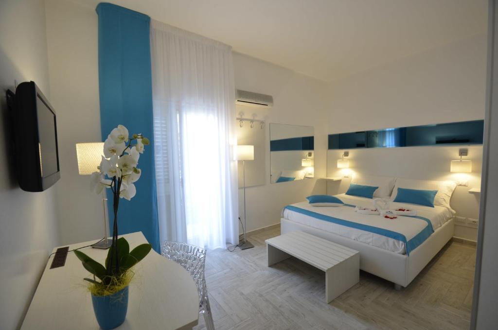 切萨雷奥港Di Ma B&B的白色和蓝色的卧室配有床和桌子