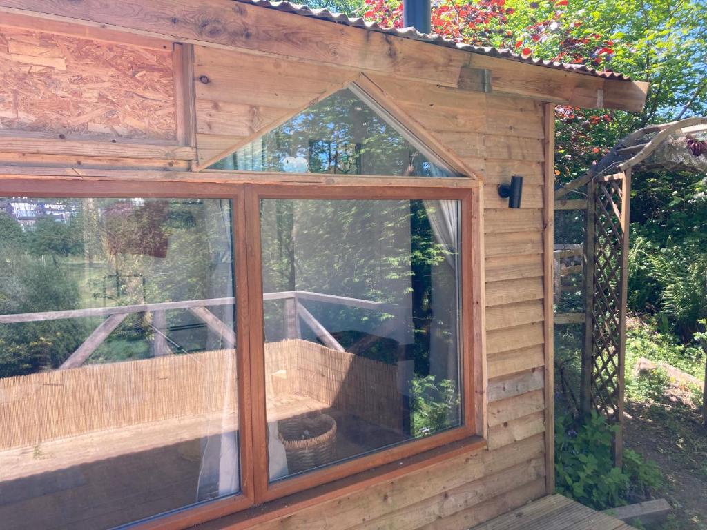 兰达西尔Honey Bee Cabin的花园内带窗户的木制温室