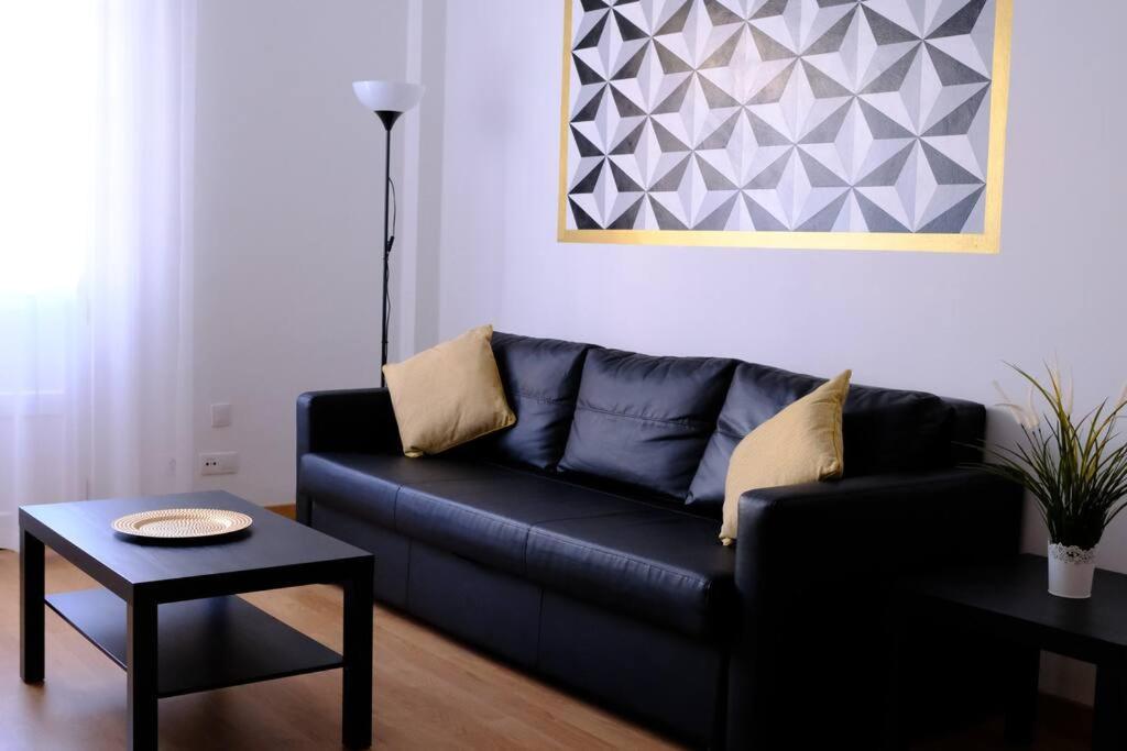 圣克鲁斯-德特内里费Orán Tenerife Suites Ap. 11的客厅配有一张黑色沙发,设有一张桌子