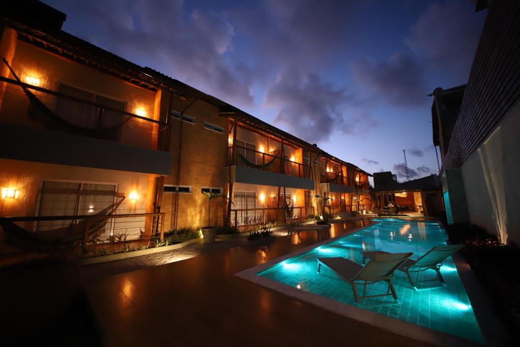 马拉戈日Uri Pousada的一座晚上设有游泳池的建筑