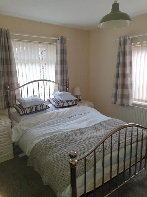 SuttonEllesmere port的卧室内的一张床位,设有两个窗户
