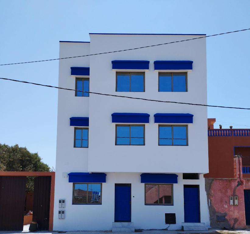 沃利迪耶Appartement Hajar的白色的建筑,设有蓝色的窗户