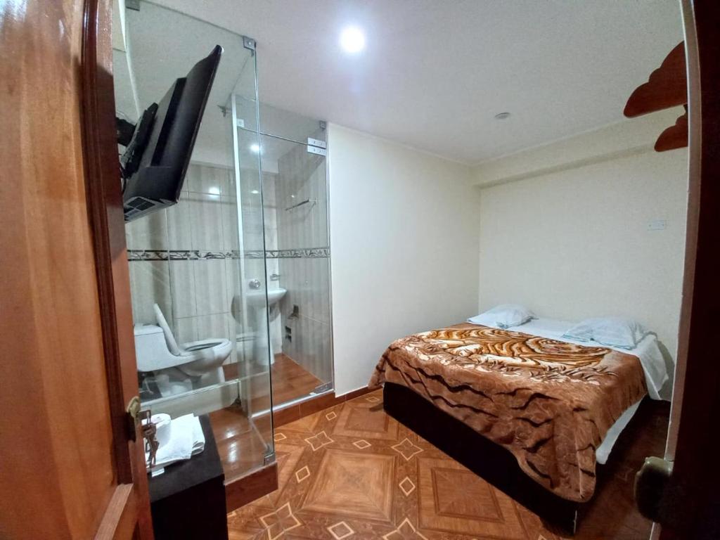 瓦努科KISWAR的一间卧室设有一张床和一个玻璃淋浴间
