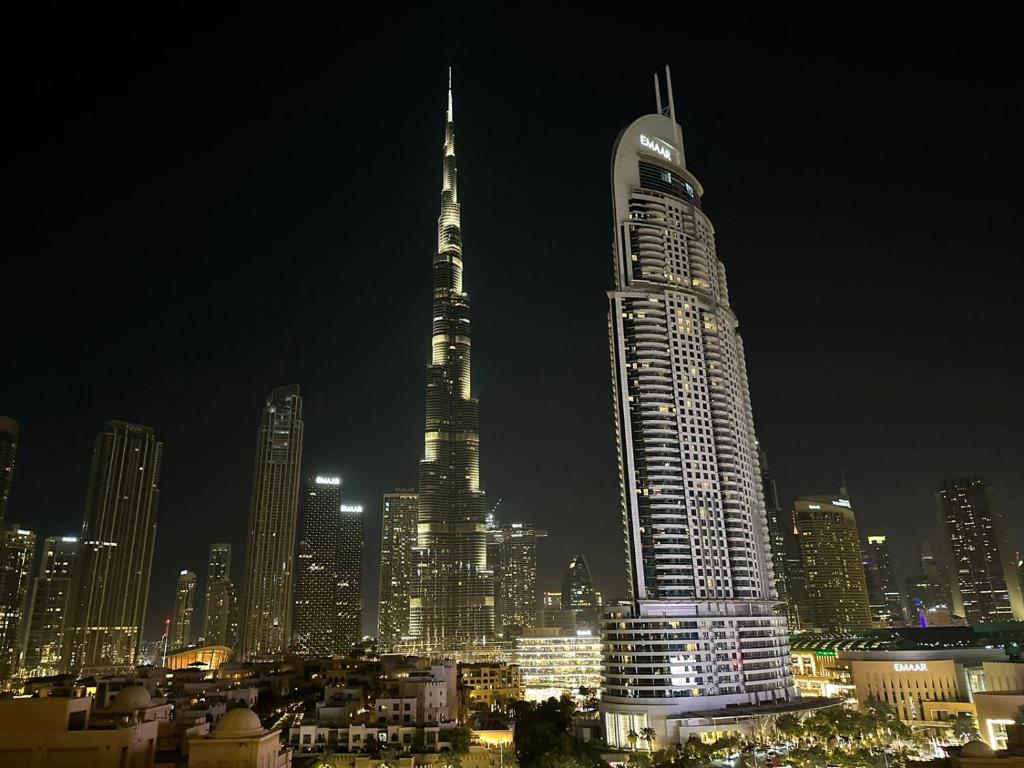 迪拜DownTown, Dubai Burj Royale 2 BDR Apartment Full Burj - Khalifa view的城市天际线,夜晚有高楼