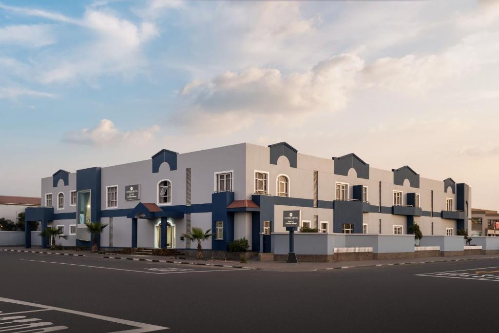 鲸湾港Protea Hotel by Marriott Walvis Bay Indongo的街道上建筑物的建筑 ⁇ 染