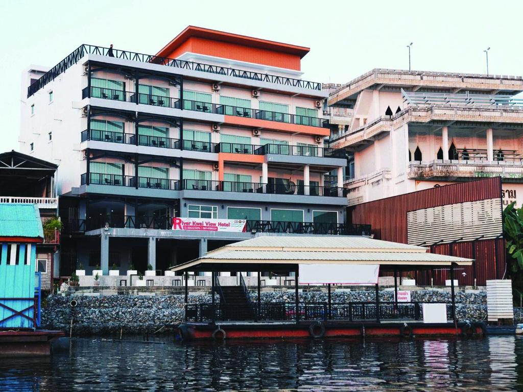 北碧River Kwai View Hotel - SHA Extra Plus Certified的建筑物前的水中船只