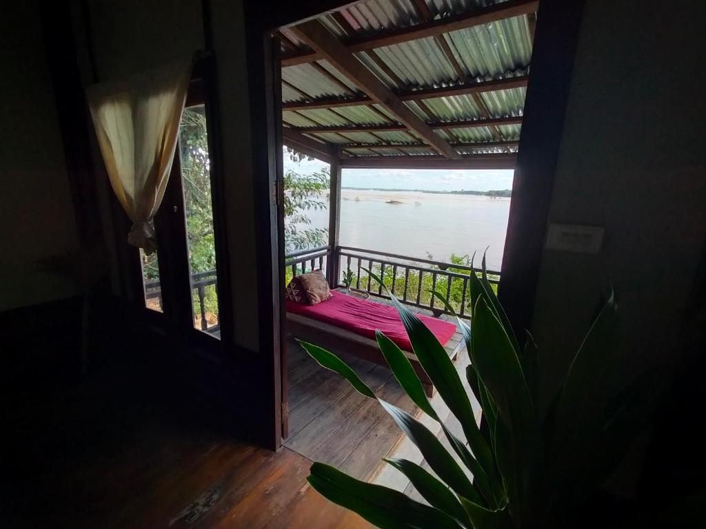Ban KhonPomelo Restaurant and Guesthouse's Fishermen Bungalow & A Tammarine Bungalow River Front的客房设有一个享有水景的阳台。