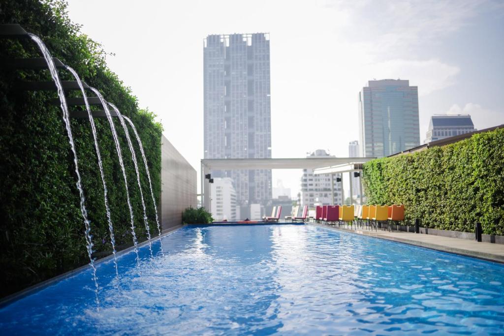 曼谷ibis Styles Bangkok Silom的城市中一个带喷泉的游泳池