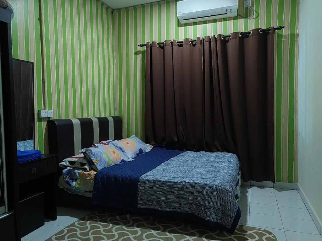 Kampong JemamparTeratak Delisha -musslim的一间卧室设有绿色条纹墙和一张床