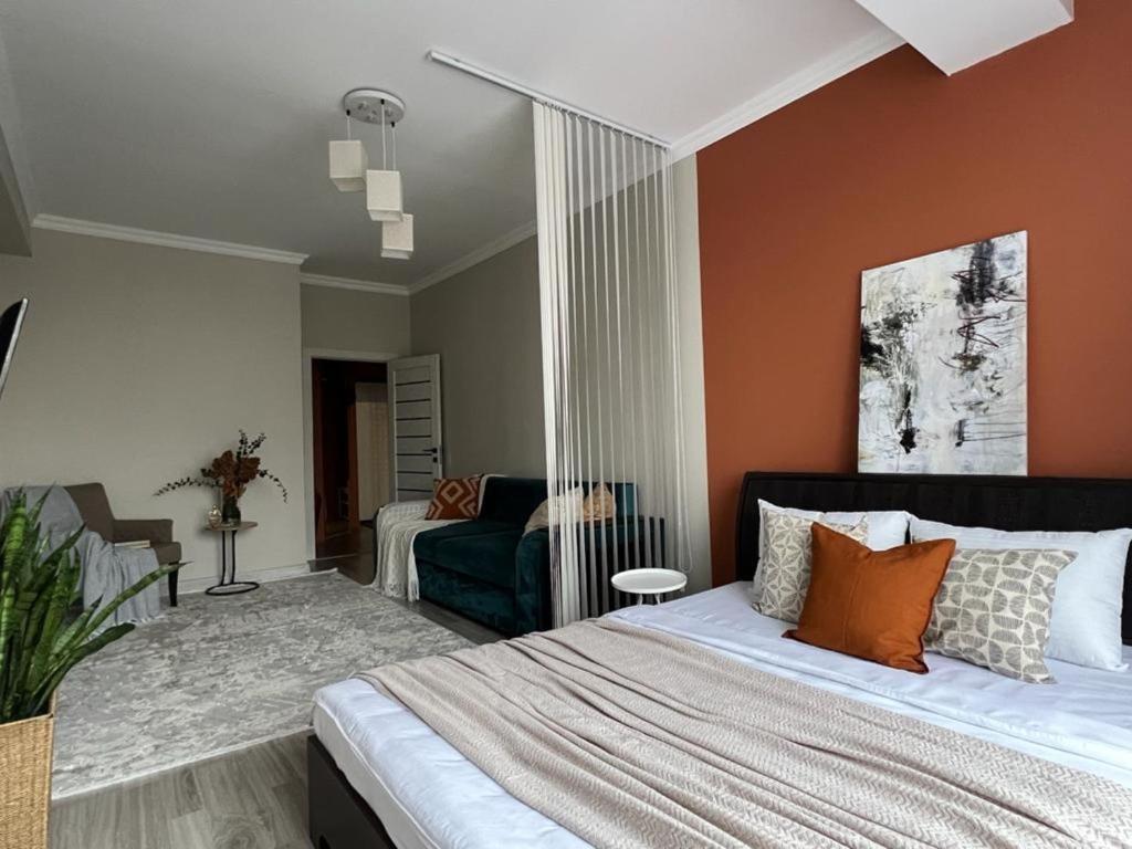 阿拉木图Просторные двухкомнатные апартаменты Терракота的一间卧室配有一张大床和一张沙发