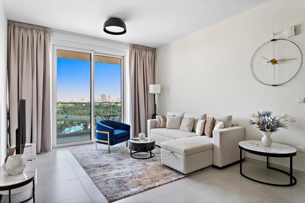 迪拜Spacious 1BR APT Wasl的客厅配有白色沙发和大窗户
