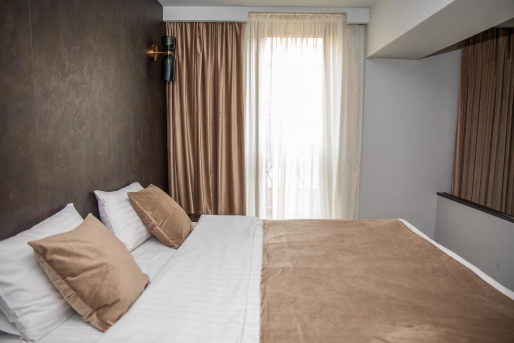 埃里温卡斯凯德酒店 的卧室配有带枕头的白色床和窗户。