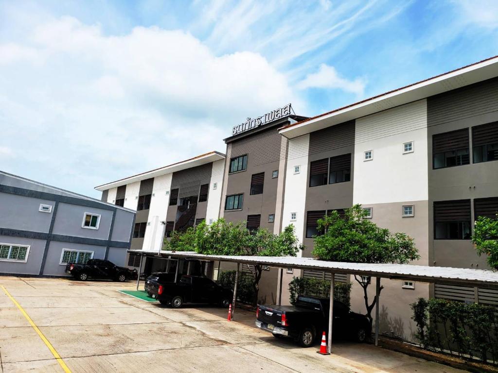 武里南Thanaphat place的停车场内有车辆停放的公寓大楼