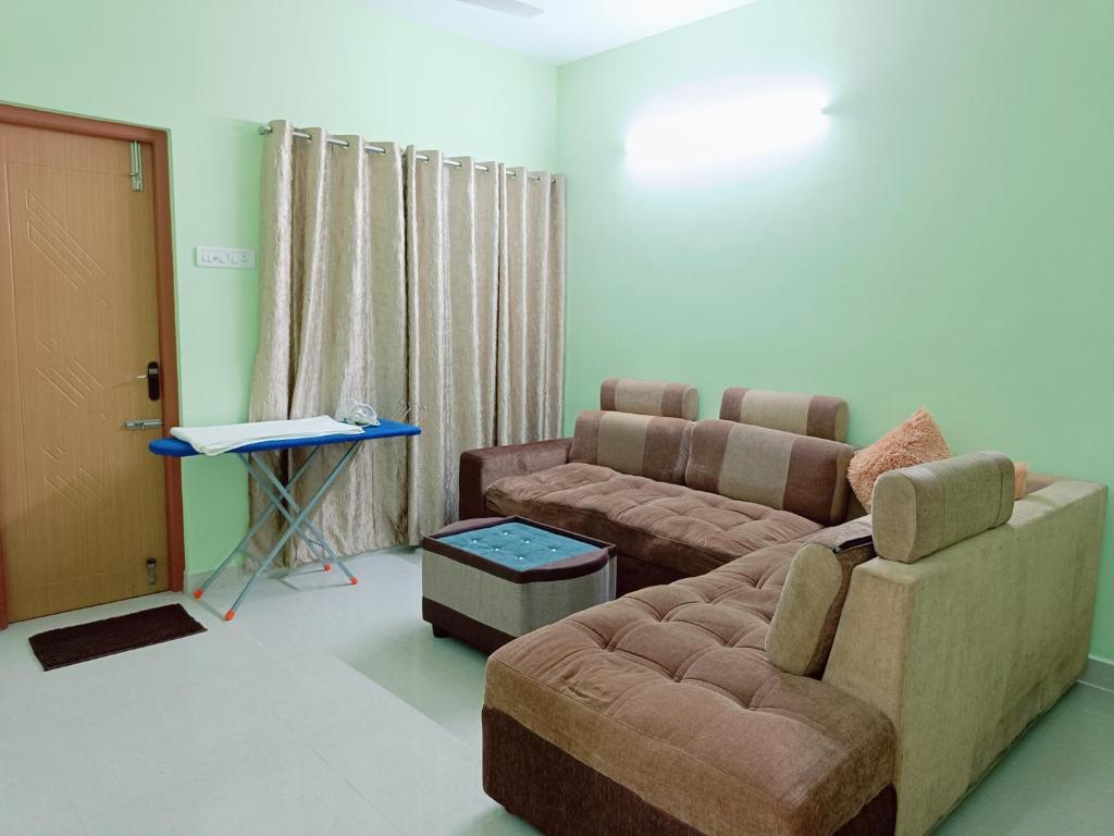 钦奈Ananya service apartments的客厅配有沙发和桌子