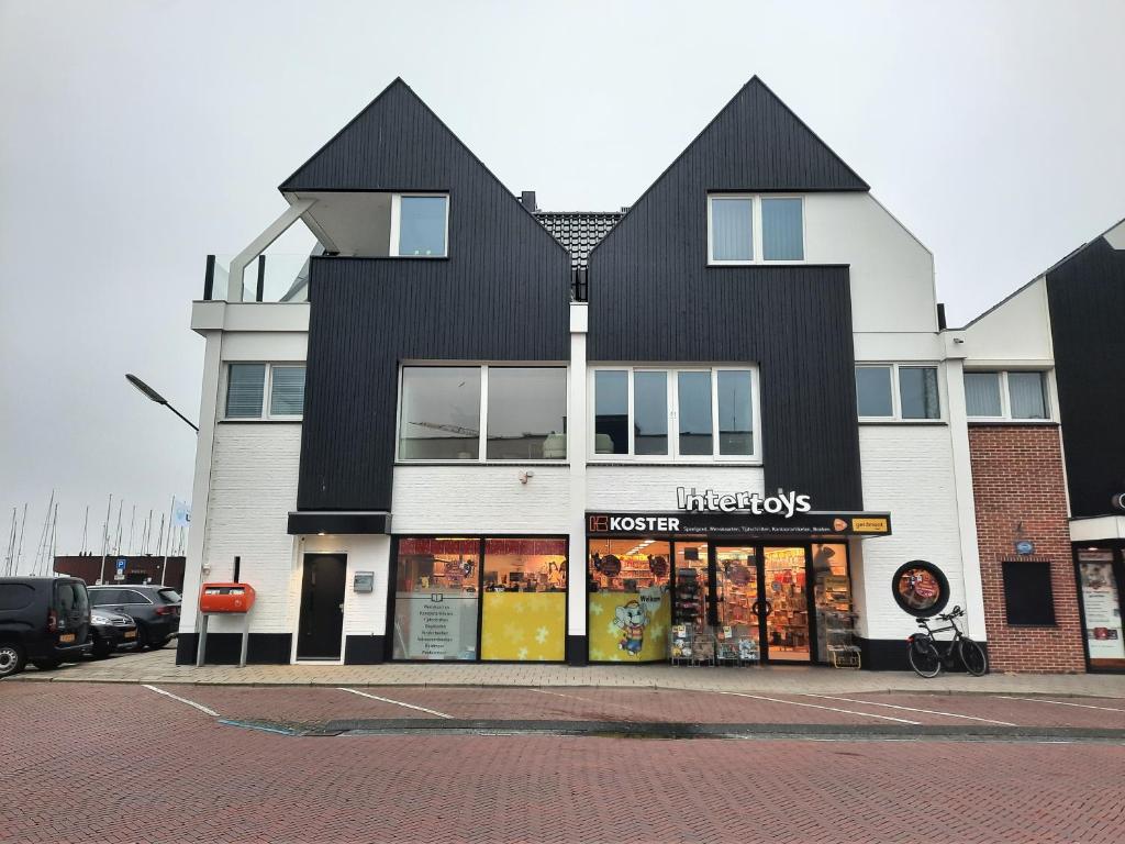 于尔克Bij de Haven op Urk的一座黑白的大建筑,有商店