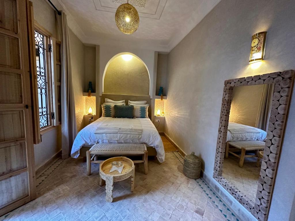马拉喀什Riad Citrus的一间卧室配有一张大床和镜子