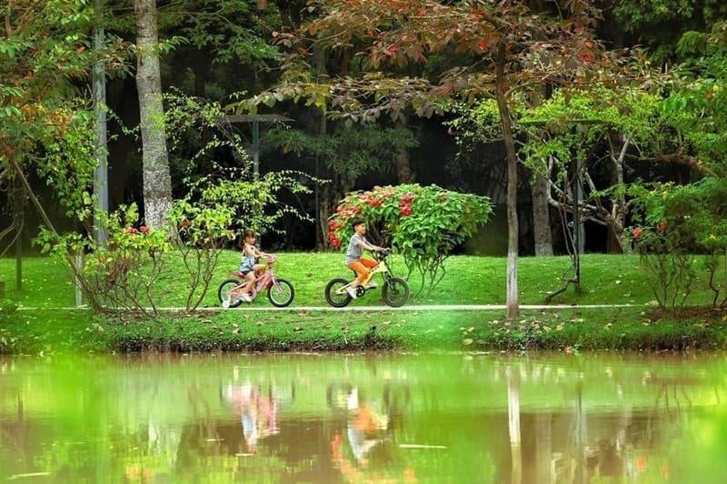兴安Ecopark Happy Haven的两人在池塘旁的公园骑车