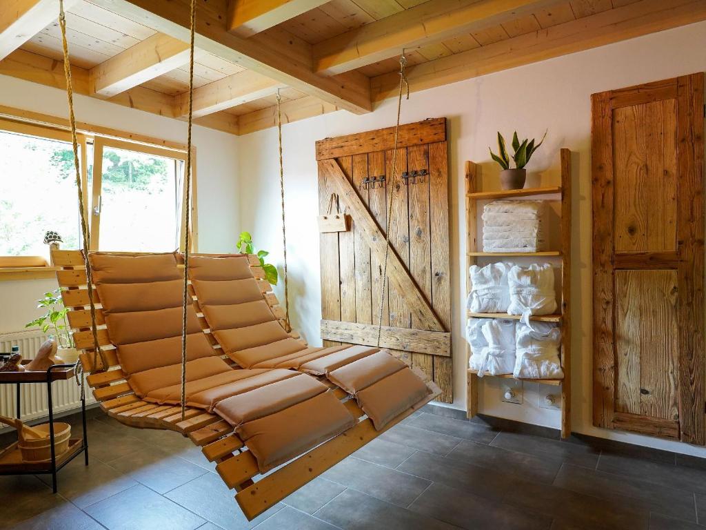 劳特巴斯Heimatglück的配有木制天花板的客房内的摇摆椅
