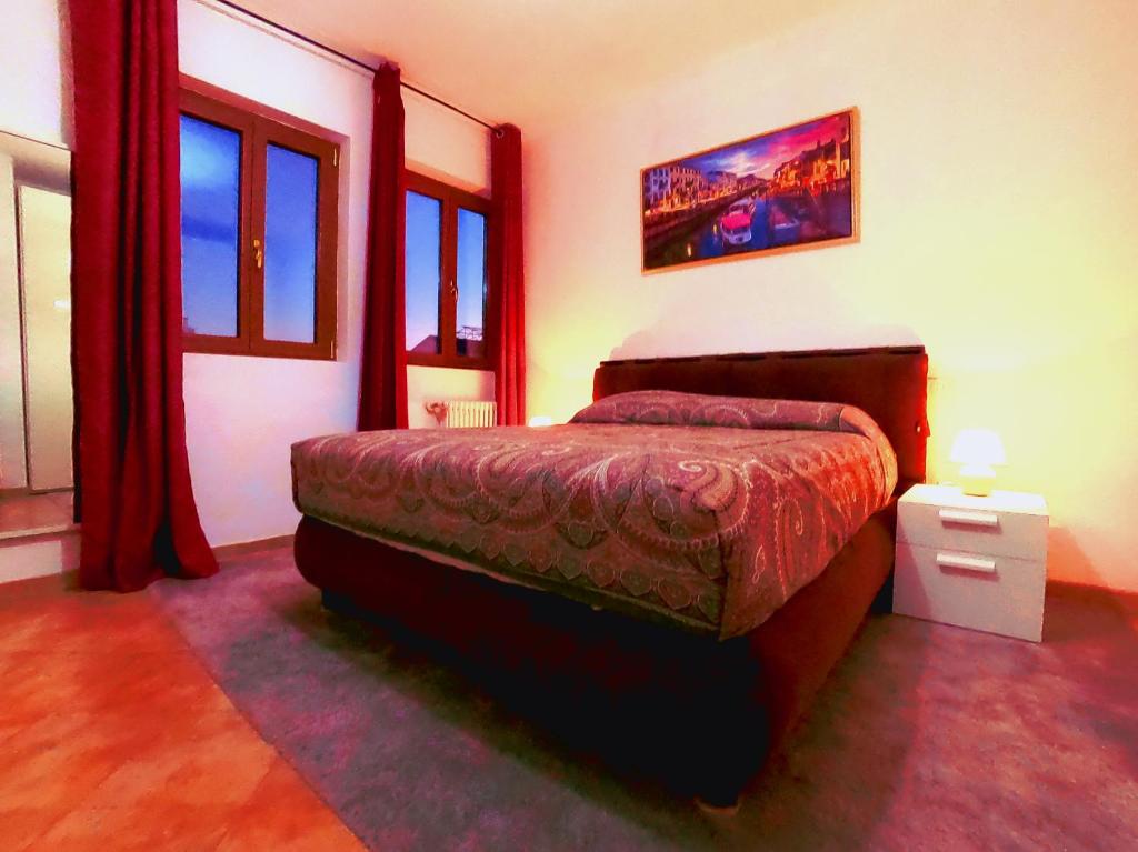 米兰L' appartamento sul Naviglio的一间设有床铺的卧室,位于带窗户的房间内