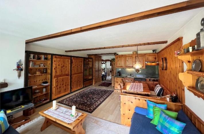库尔瓦尔登Alpine Cocoon的一个带木制橱柜的大厨房和一个客厅