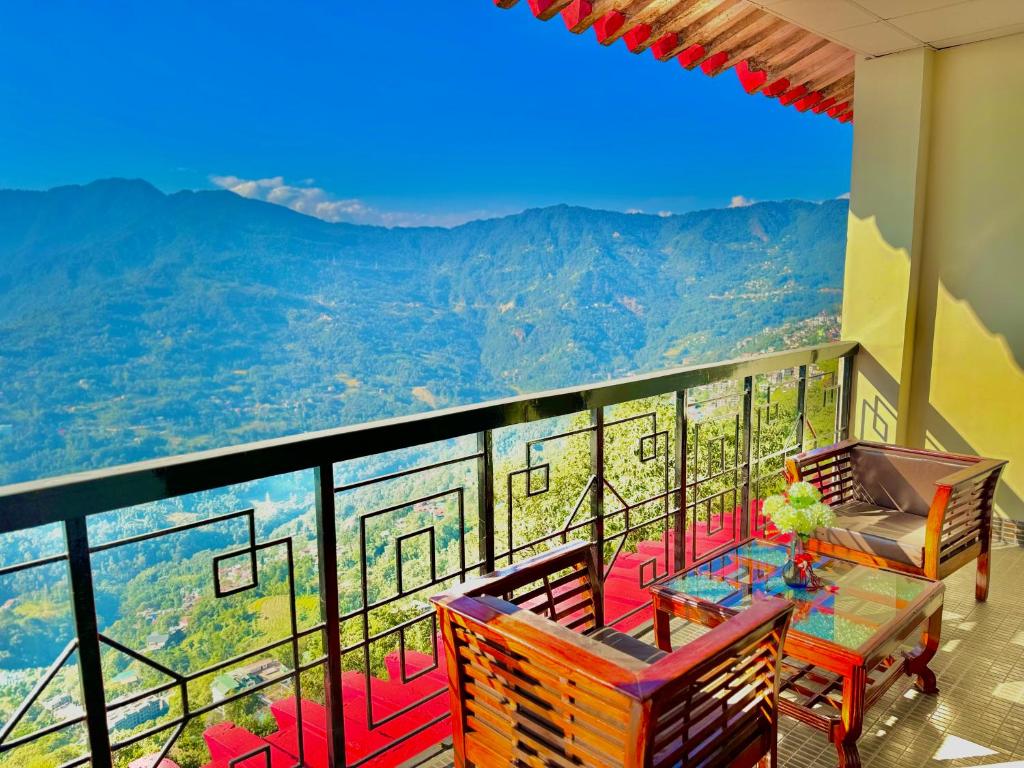 甘托克Tara Palace Resort and SPA的设有一个配有桌椅并享有美景的阳台。