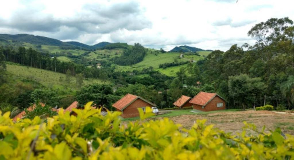 索科罗Pousada Ecológica Rio do Peixe的田野上山丘上的一群房子