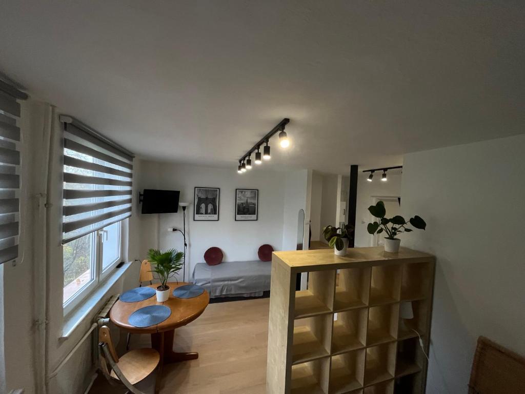华沙Murano Apartaments Promenada studio的带桌子的房间和一间带床的卧室