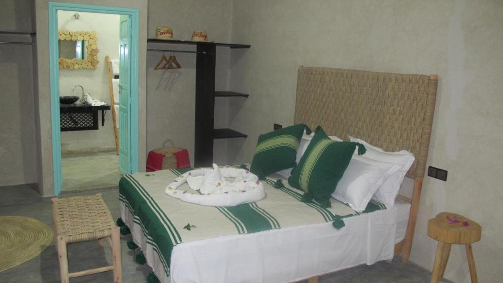 马拉喀什Family Village Marrakech的一间卧室配有带绿色和白色枕头的床