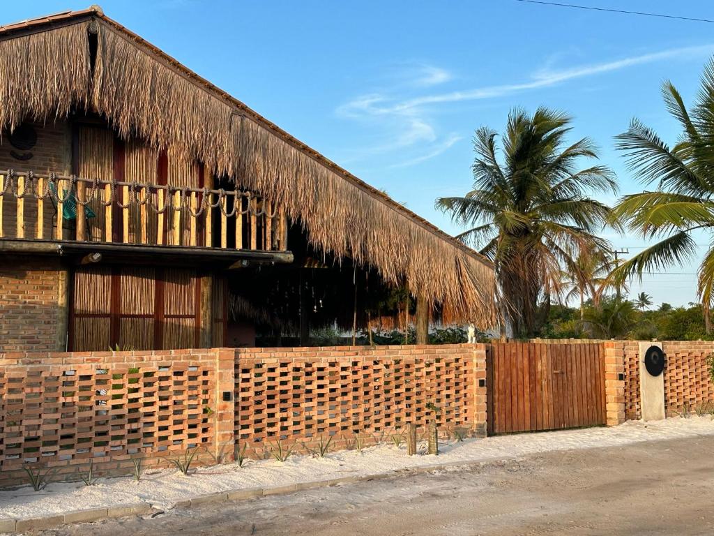 普拉杜Casa Chão的一座带围栏和棕榈树的建筑