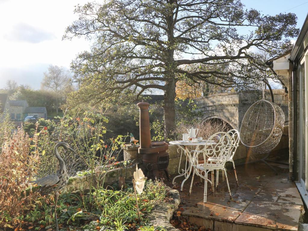 贝克韦尔Toll Bar Cottage的花园内带桌椅的庭院