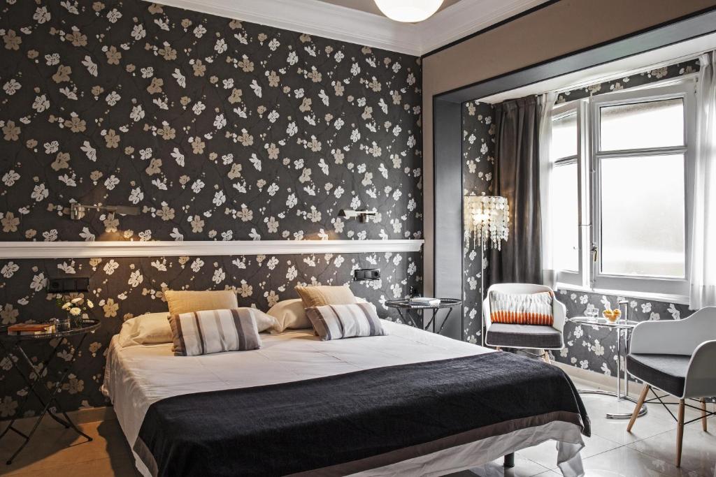 巴塞罗那恩艾克蒙塔纳酒店的一间卧室设有床铺,墙上有鲜花