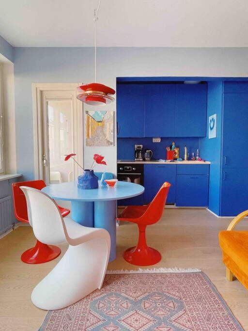 赫尔辛基Ihana kaksio Linnanmäen vieressä的厨房配有桌椅和蓝色橱柜。
