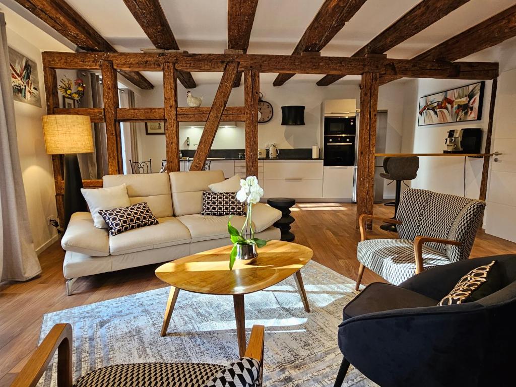 凯泽贝尔Gîte Du XVe的客厅配有沙发和桌子