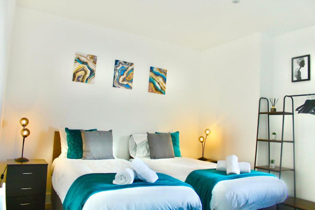 赫默尔亨普斯特德Hemel Apartments- Tranquil Haven的蓝色和白色的客房内的两张床