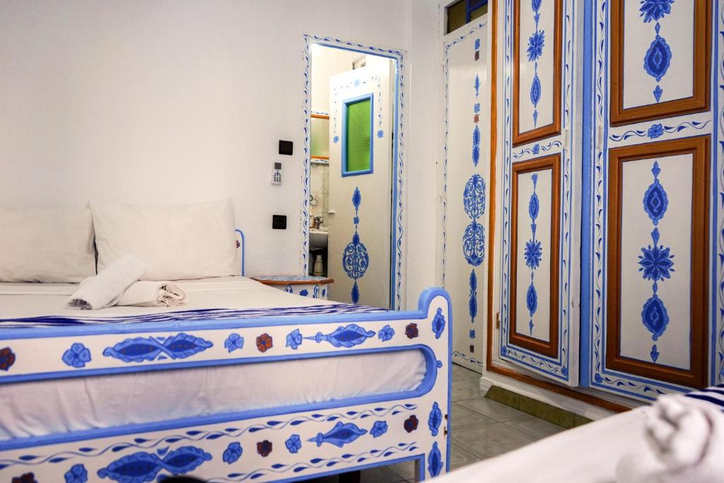 舍夫沙万Hotel Marrakech的一间蓝色和白色的卧室,配有一张床和镜子