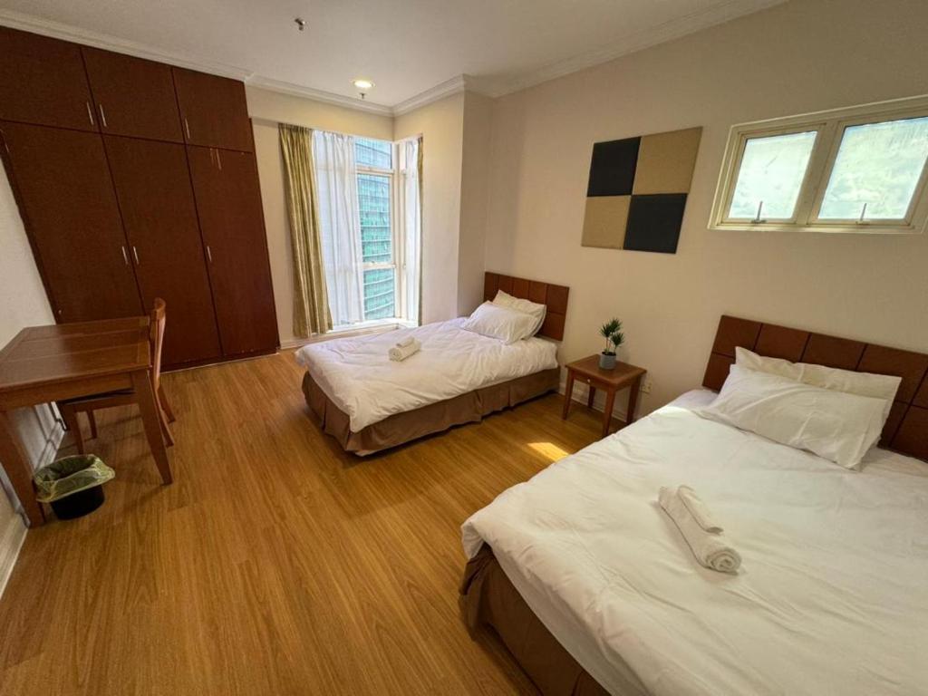 古晋StayInn Gateway Hotel Apartment, 2-bedroom Kuching City PrivateHome的酒店客房配有两张床和一张书桌