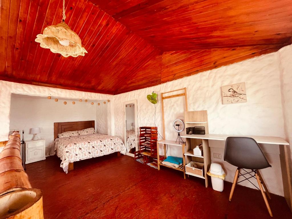 万查科Huanchaco Domes的一间卧室设有一张床和木制天花板